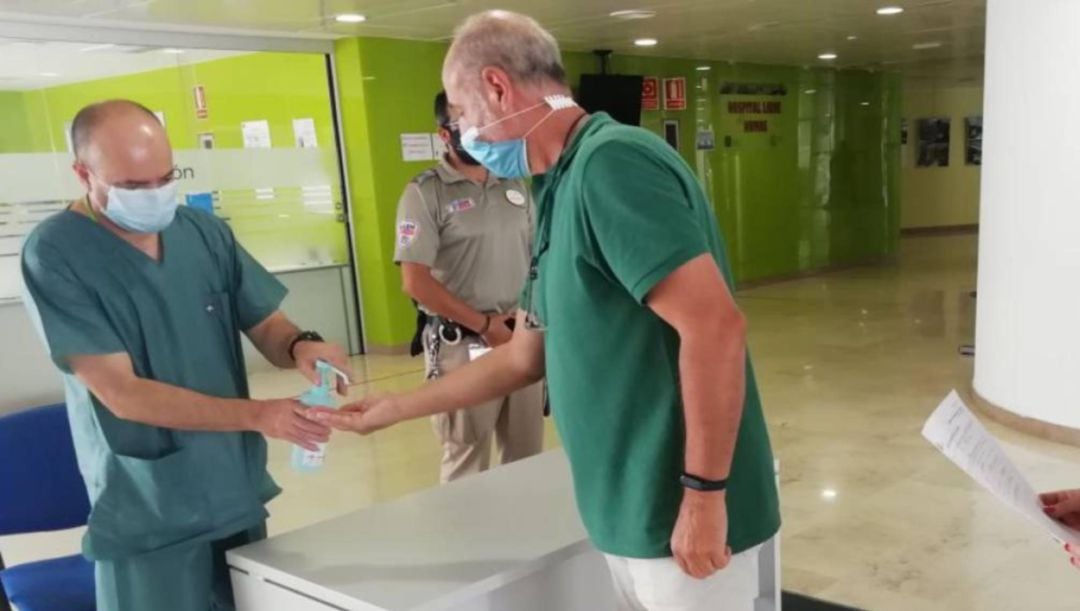 Dos profesionales sanitarios se desinfectan las manos a la entrada del hospital de Jaén.