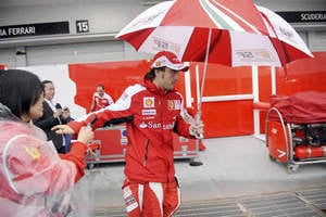 Fernando Alonso camina bajo la lluvia tras suspenderse la sesión de clasificación en Suzuka (Japón)