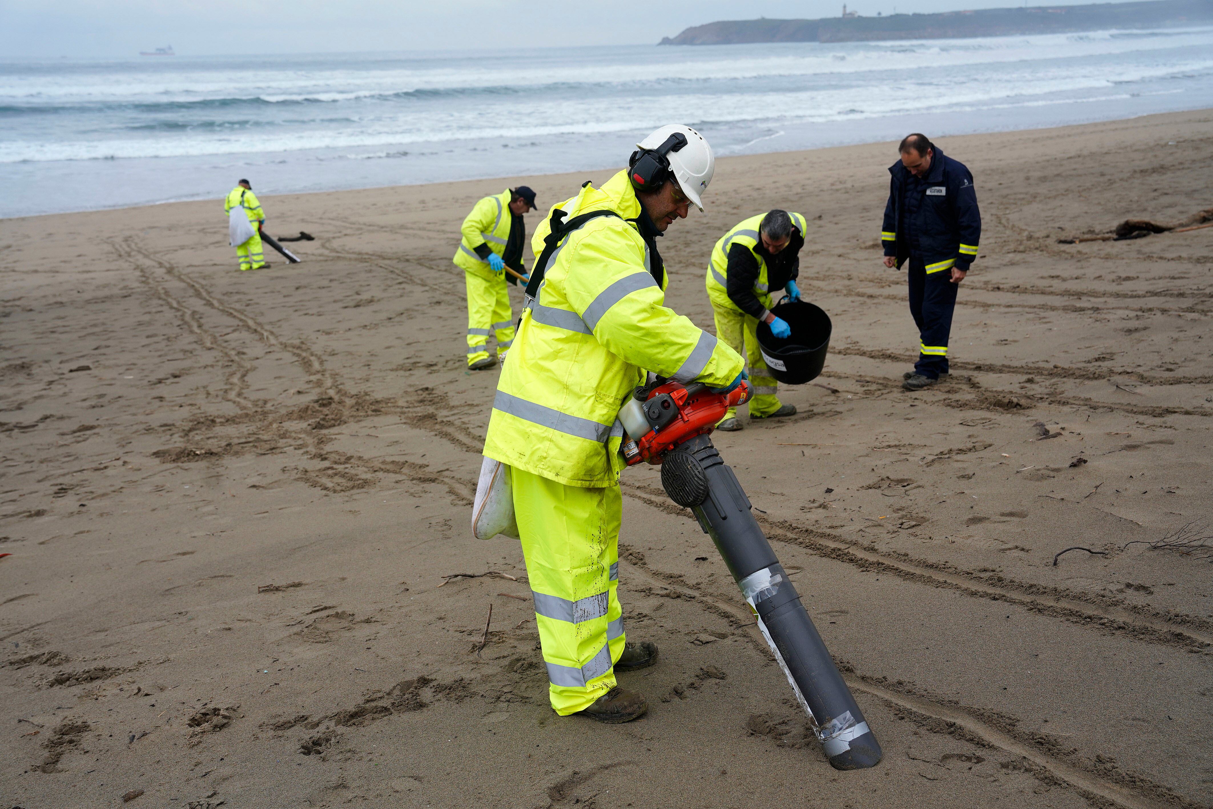 PLAYA DE SALINAS (ASTURIAS), 10/01/2024.- Operarios con aspiradores esta mañana en la playa asturiana de Salinas. El Principado ha identificado 65 de los 210 arenales asturianos como prioritarios para los trabajos de vigilancia y retirada de los &#039;pellets&#039; microplásticos llegados a la costa, en los que este miércoles participan unas 170 personas. EFE/Paco Paredes
