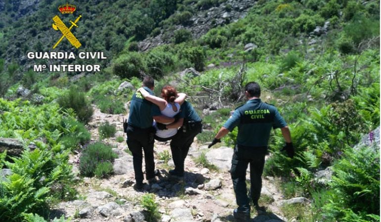 Agentes de la Guardia Civil llevan en volandas a una de las mujeres accidentadas