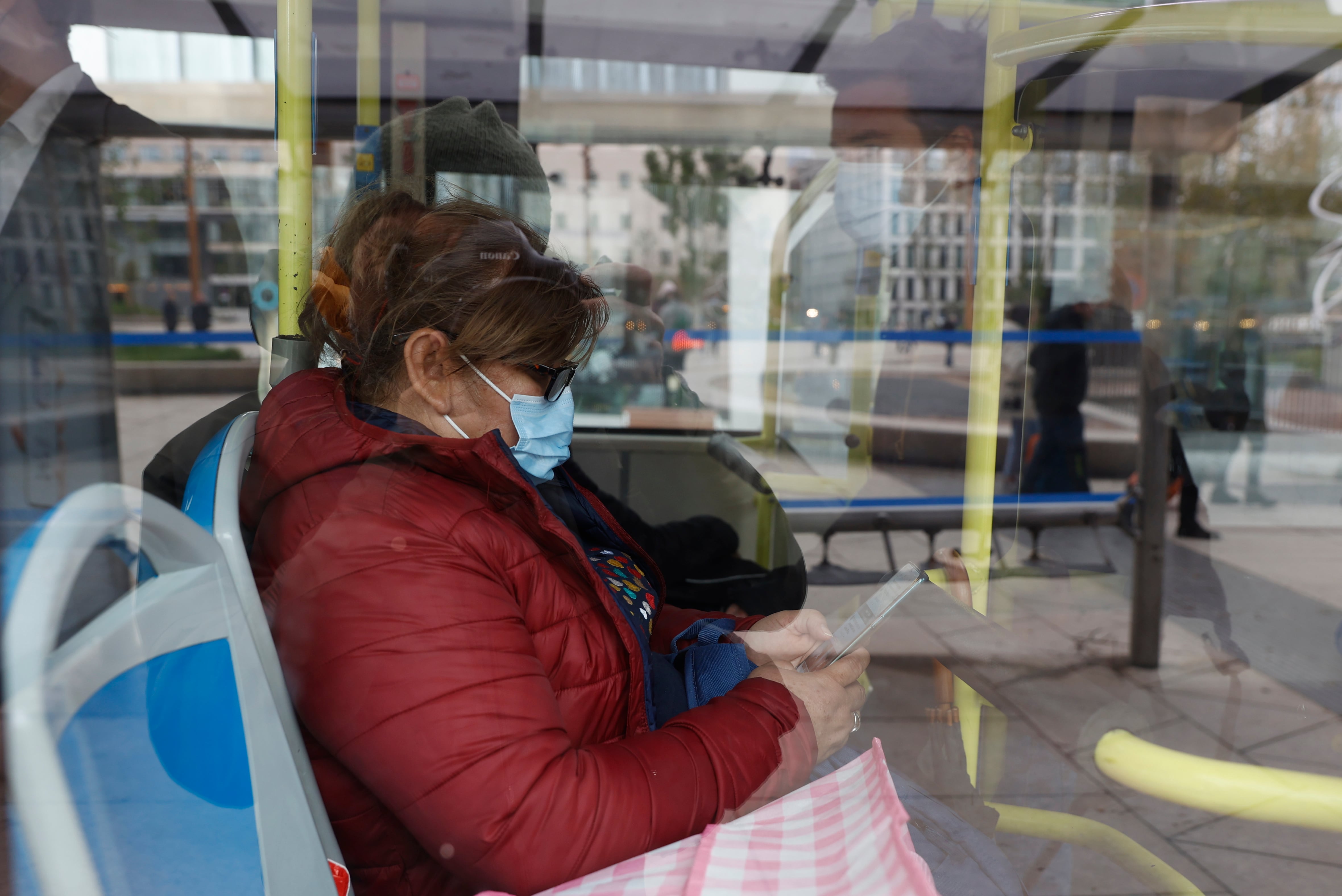 Una mujer lleva una mascarilla en un autobús urbano.