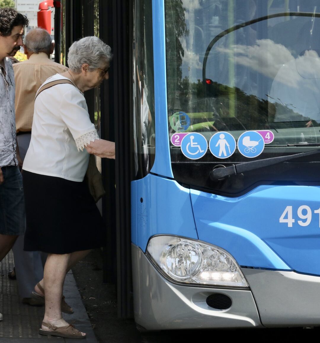 Una mujer de la tercera edad, sube a un autobús de la EMT.