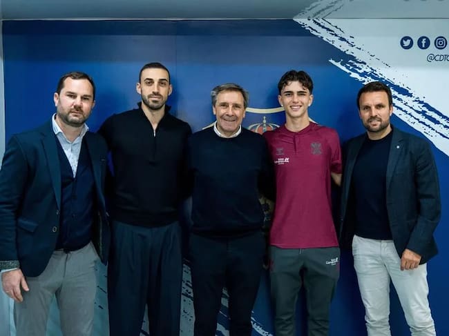 Dani Fernández escoltado por Felipe Miñambres, Ayoze García y el staff técnico del club.