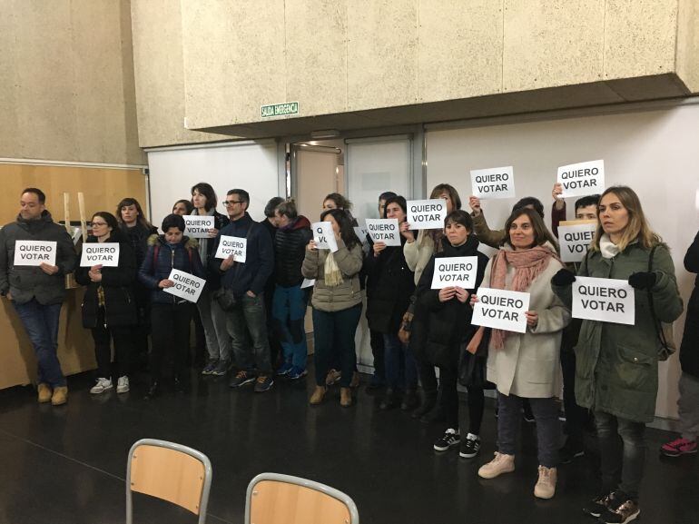 Padres a favor de la jornada continua se concentran silenciosamente mientras se da una charla sobre la partida