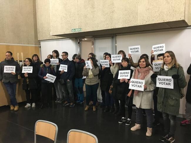 Padres a favor de la jornada continua se concentran silenciosamente mientras se da una charla sobre la partida