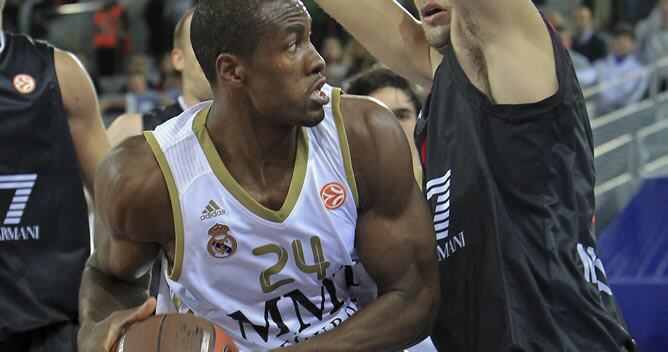 El ala-pívot del Real Madrid Serge Ibaka (i) controla el balón ante la oposición de un jugador del equipo italiano Emporio Armani Milán durante el partido de la segunda jornada de la Euroliga que disputan en la Caja Mágica