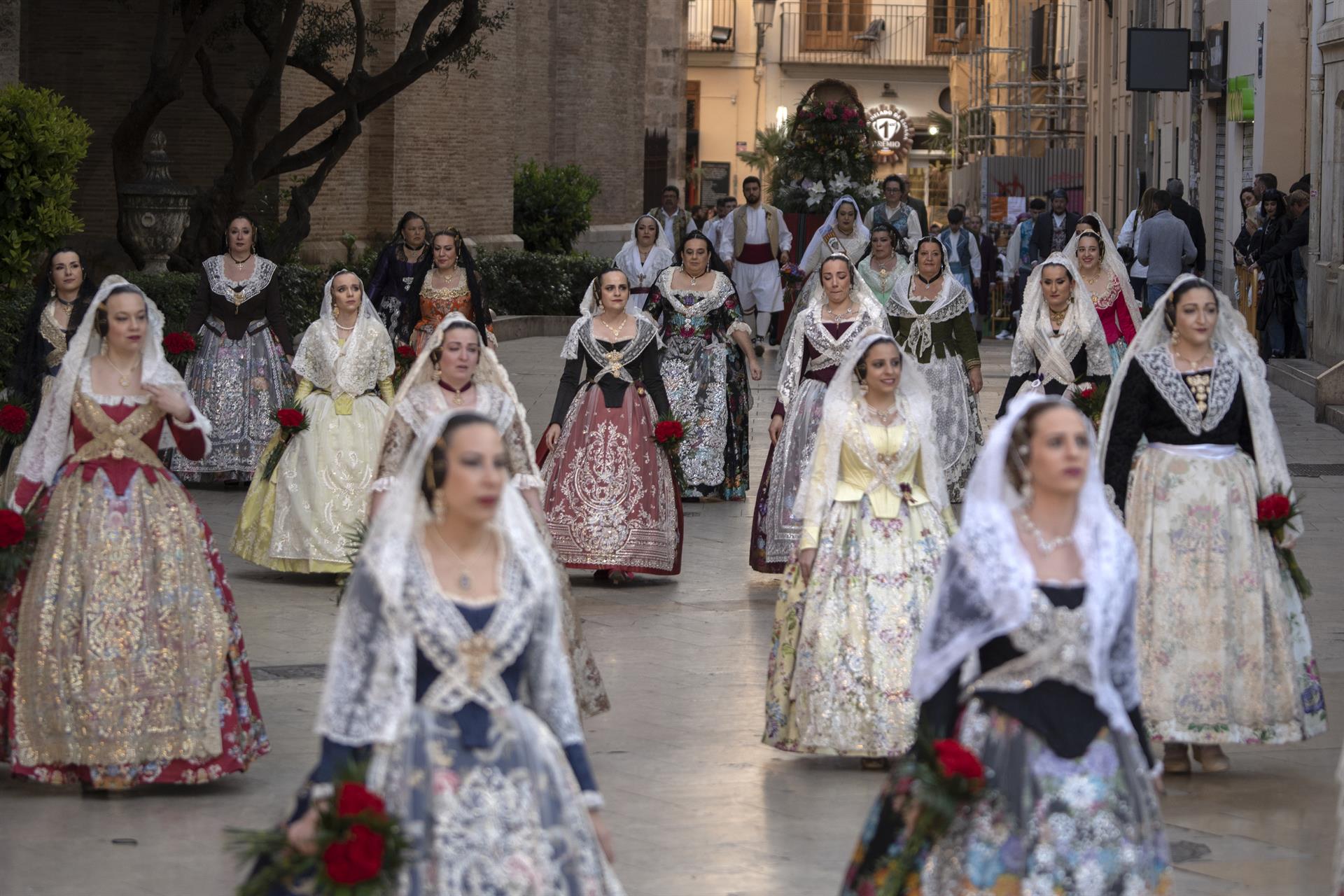 Imagen de archivo de falleras desfilando antes de acceder a la plaza de la Virgen de los Desamparados para una ofrenda de Fallas.