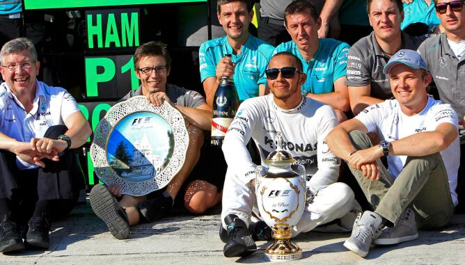 El piloto británico, su compañero Nico Rosberg y los mecánicos de Mercedes celebran la victoria en el GP de Hungría 2013.