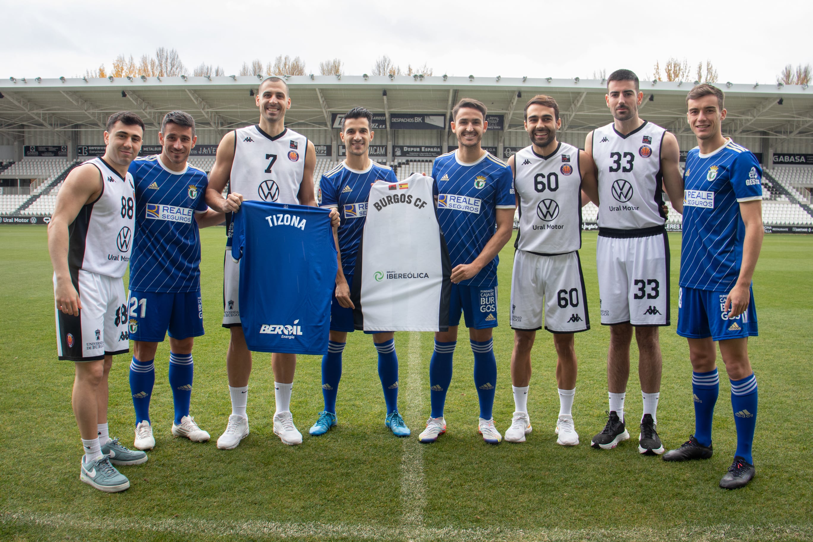 Los capitanes del Burgos CF y el Tizona Universidad de Burgos posan juntos con sus camisetas en el Estadio El Plantío.