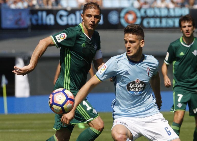 El centrocampista serbio del Celta de Vigo Nemanja Radoj disputa un balón con el jugador del Betis Joaquín Sánchez 