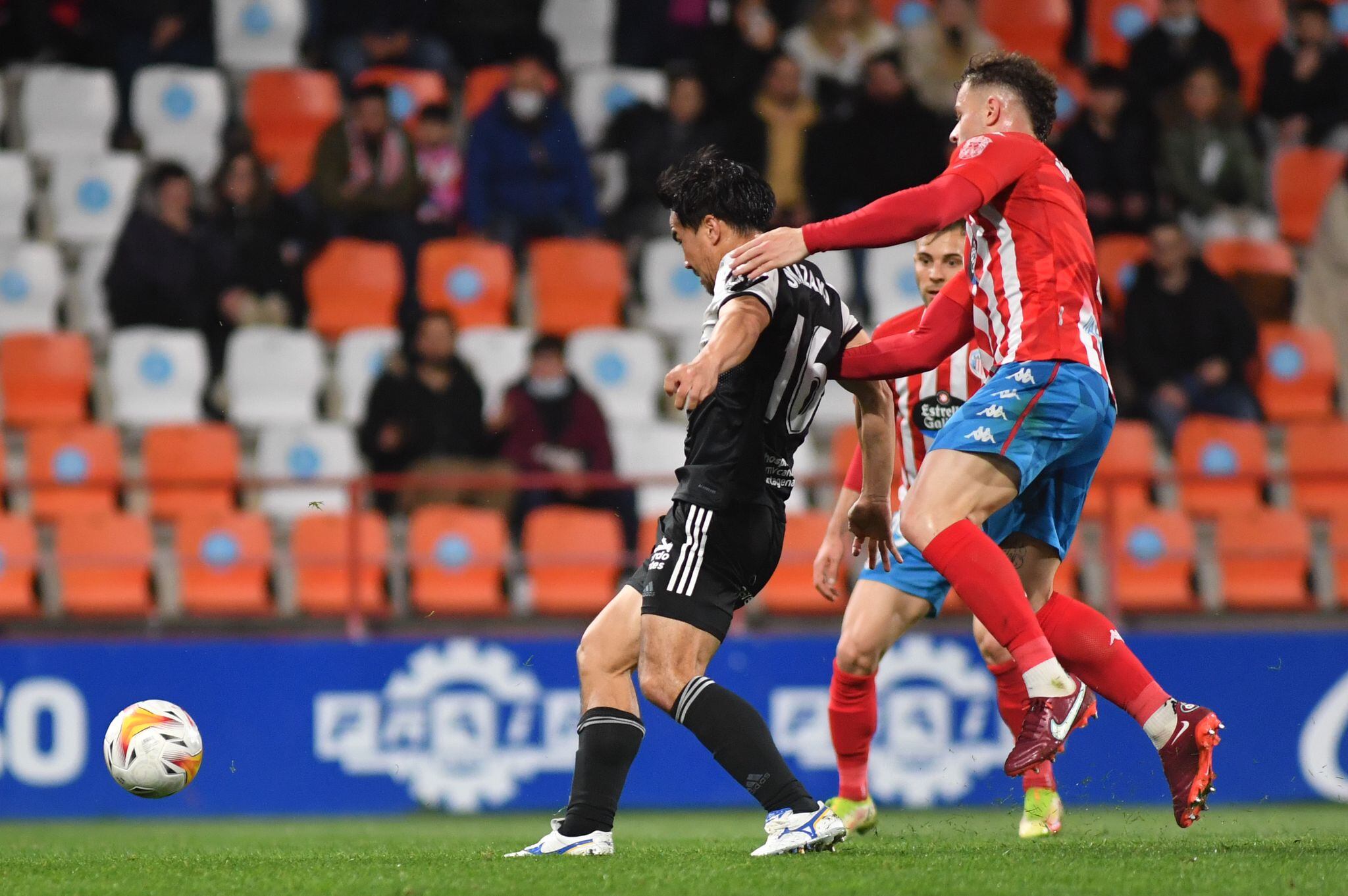 Okazaki trata de jugar el balón ante el marcaje de un defensa lucense