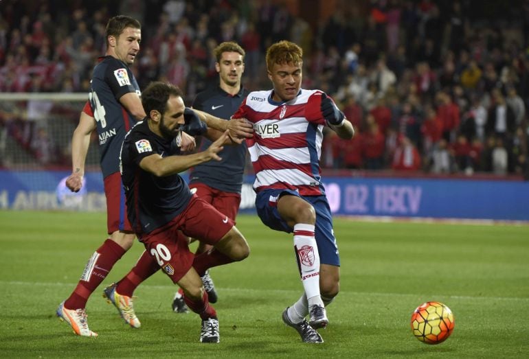  El defensa del Atlético de Madrid Juanfran Torres (c) pelea un balón con el delantero venezolano del Granada Adalberto Peñaranda (d) 