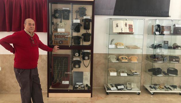 Paco Page junto a las vitrinas de su colección de teléfonos.