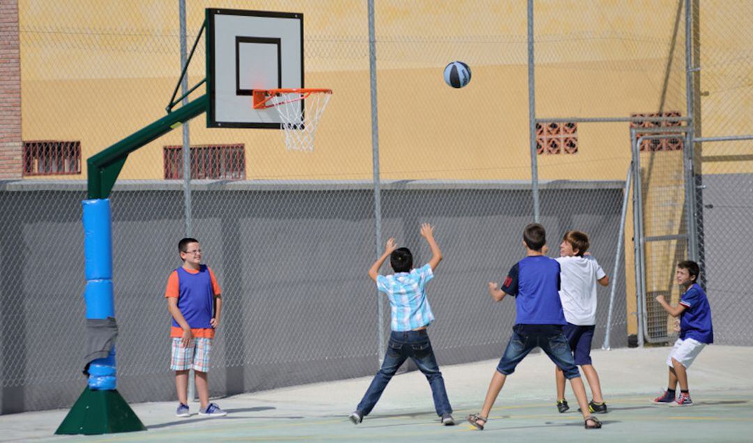 Escolares juegan a baloncesto durante un recreo