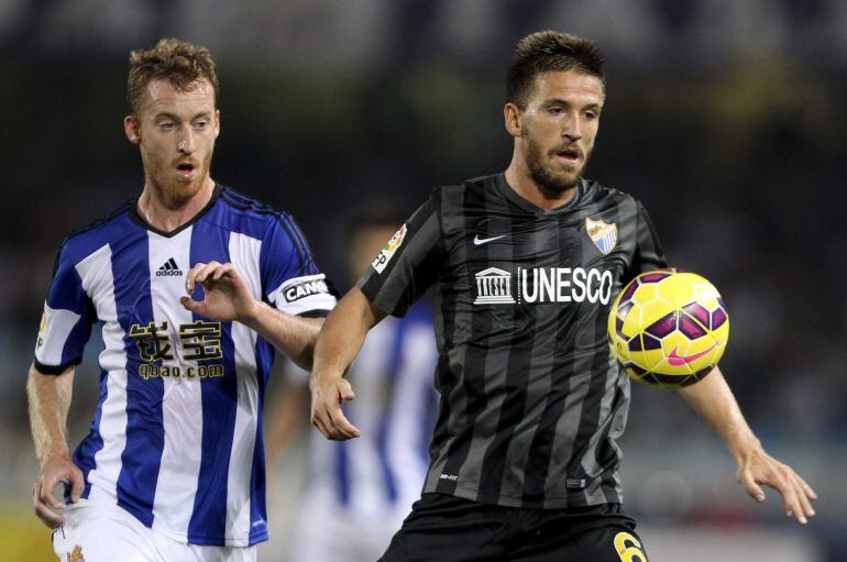 El centrocampista de la Real Sociedad David Zurutuza (i) lucha un balón con el centrocampista Ignacio Camacho (d), del Málaga CF, durante el partido de Liga de Primera División que se disputa esta noche en el estadio de Anoeta, en San Sebastián. EFE/Juan Herrero