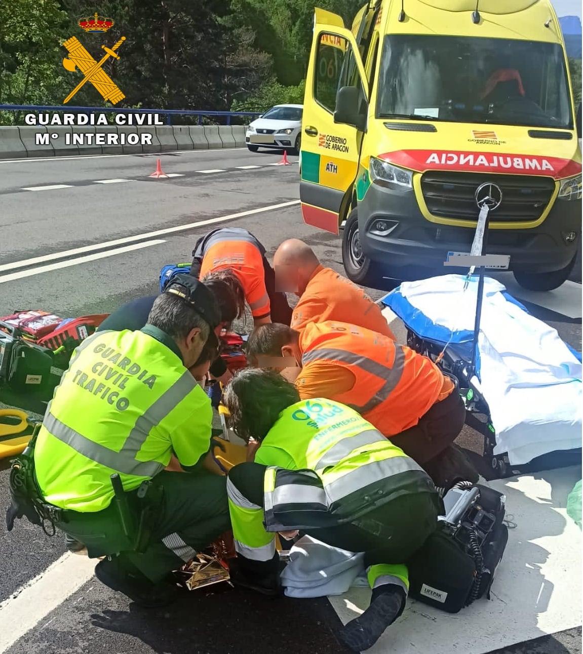 Efectivos sanitarios y de la Guardia Civil atendiendo a uno de los ciclistas