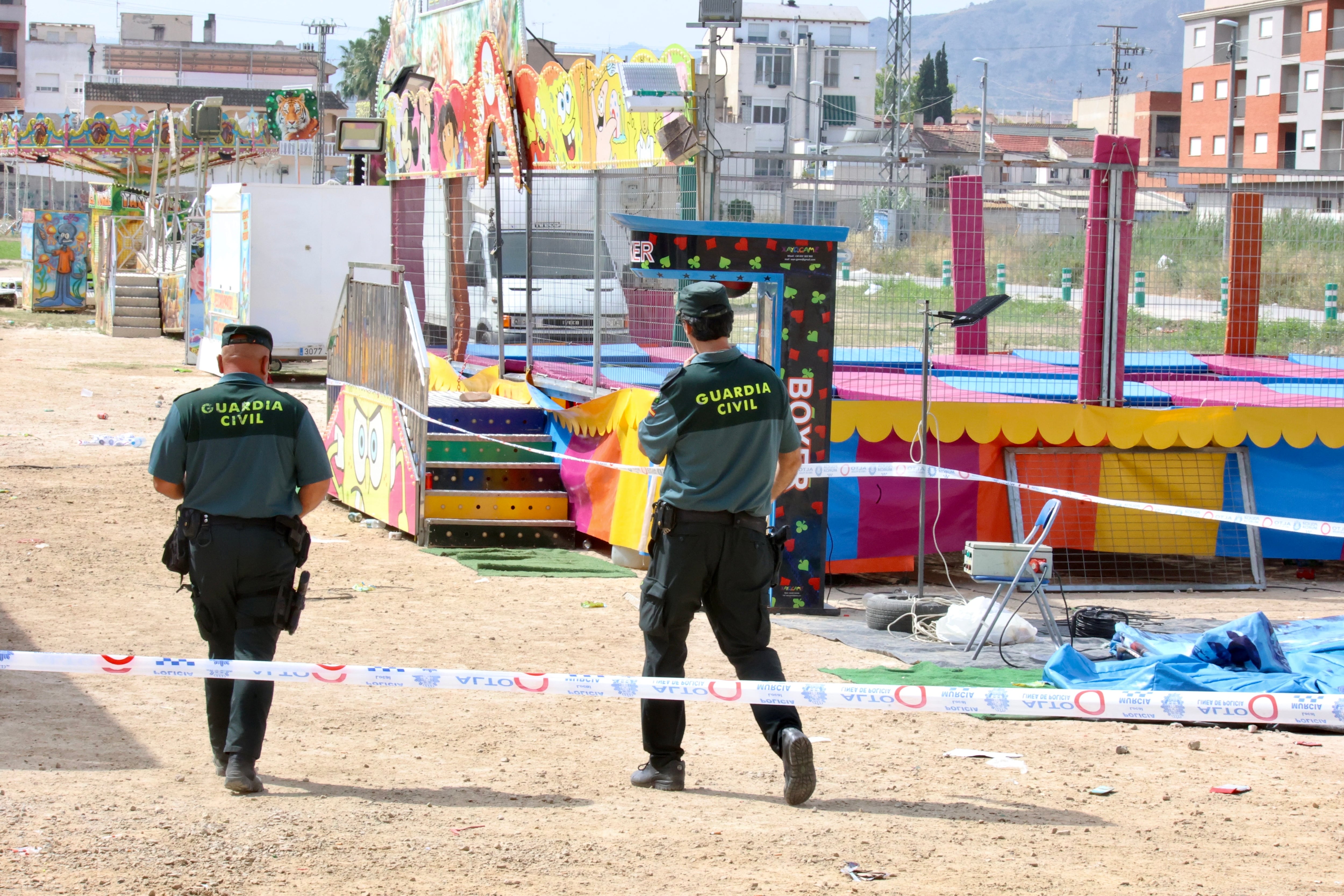 FOTODELDIA ALQUERÍAS (MURCIA), 15/06/2025.- Agentes de la Guardia Civil precintan este domingo las camas elásticas del recinto ferial de la pedanía murciana de Alquerías después de que una niña de dos años falleciera esta madrugada al recibir una descarga eléctrica. EFE/ Juan Carlos Caval
