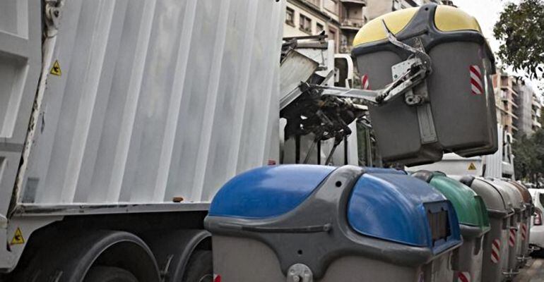 Un camión recoge la basura de un contenedor.