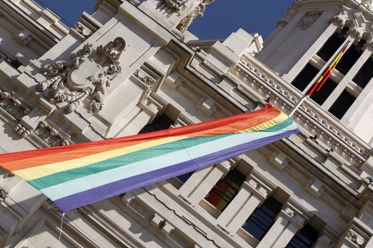 Vista de la bandera arcoíris desplegada en la fachada del Ayuntamiento de Madrid con motivo del comienzo de la semana del orgullo gay.