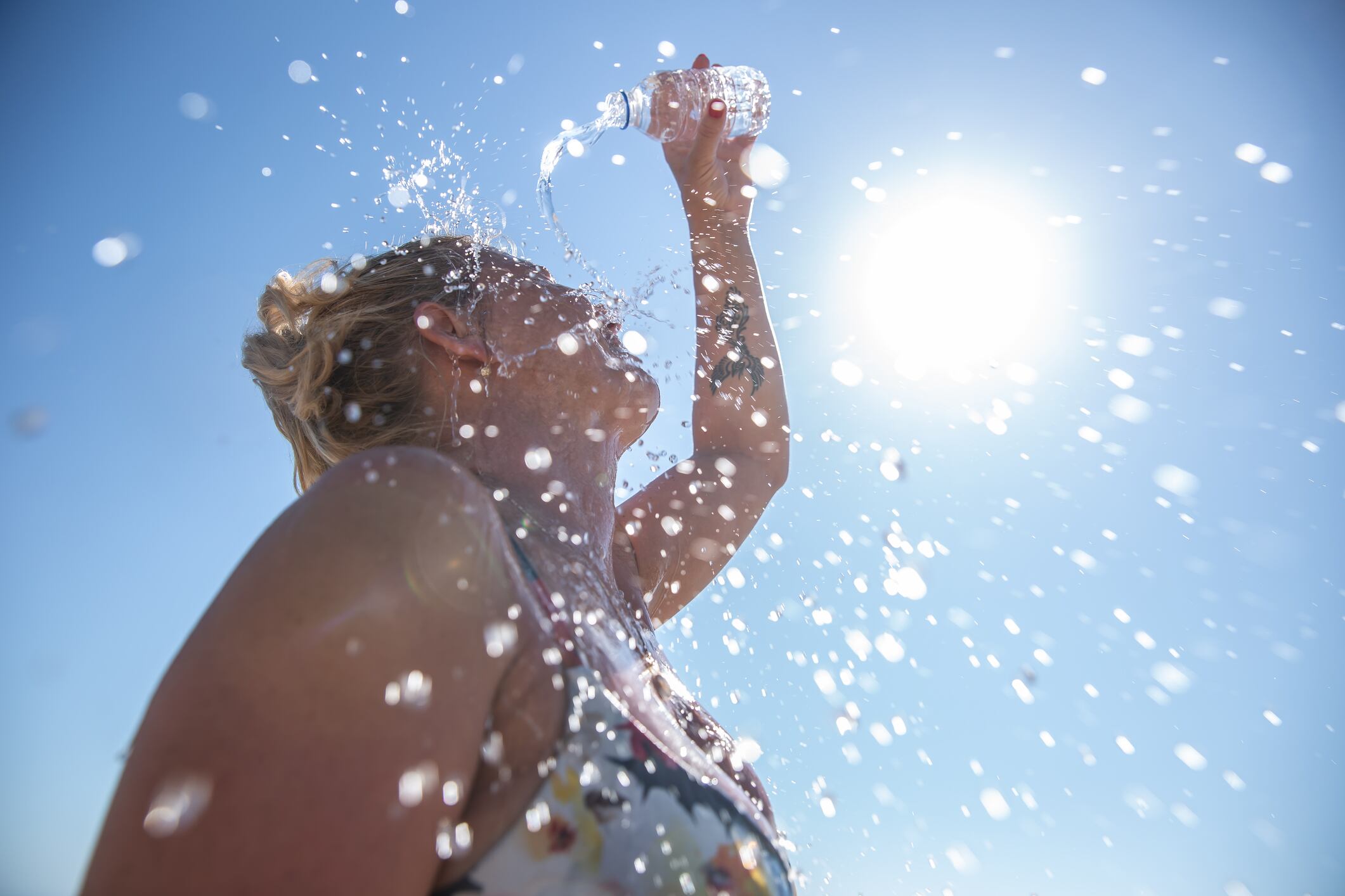 Una mujer se refresca echándose agua por el cuerpo