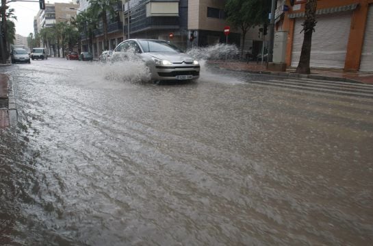 Imagen de archivo de un coche que circula entre el agua precipitada durante un episodio de lluvias torrenciales en Alicante