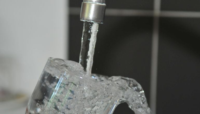 Una persona llena un vaso con agua del grifo