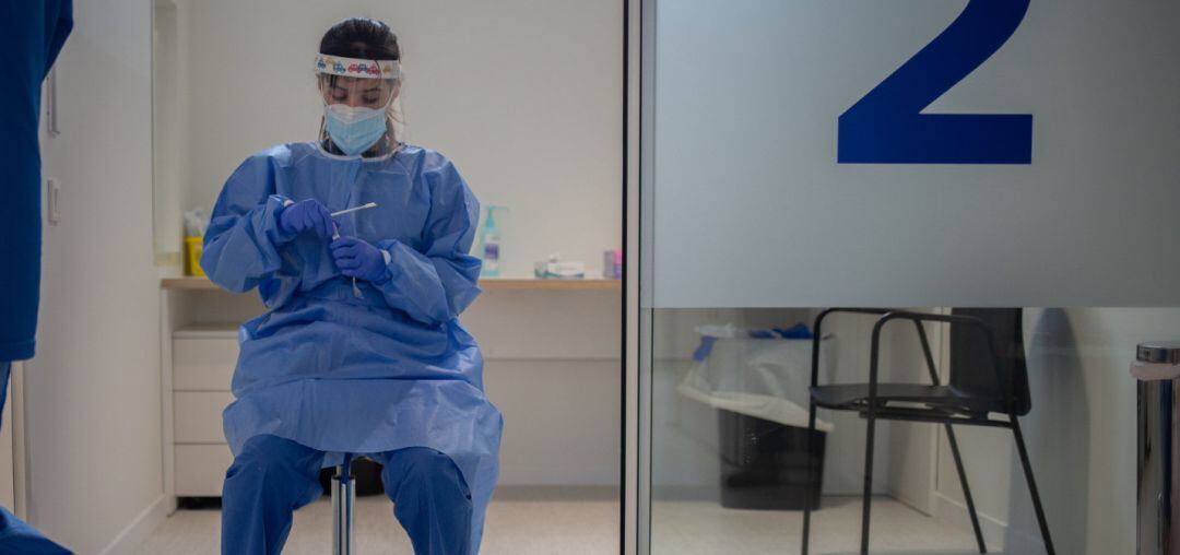 Una profesional sanitaria sostiene muestras de pruebas PCR