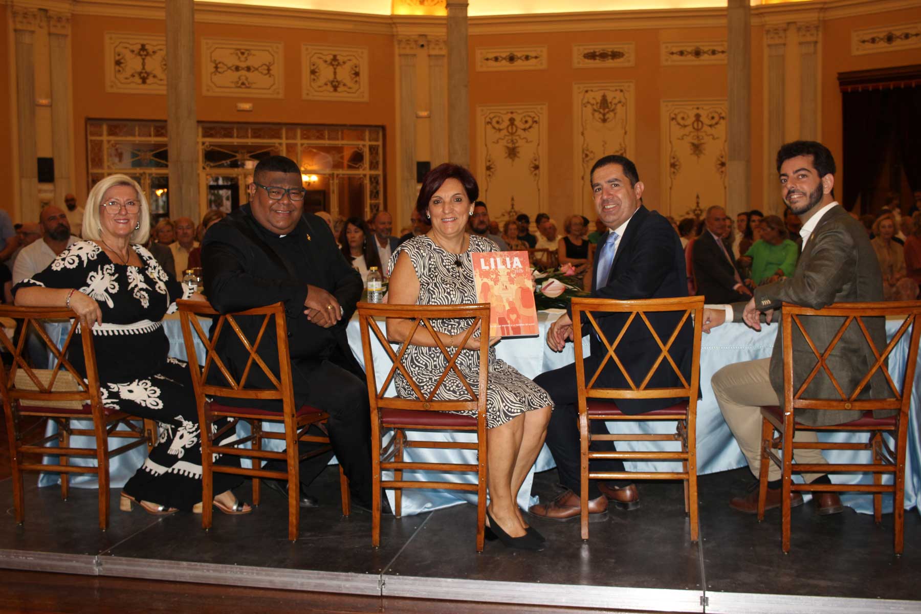 Imagen de la mesa presidencial con un ejemplar de la revista antes de empezar el acto de presentación