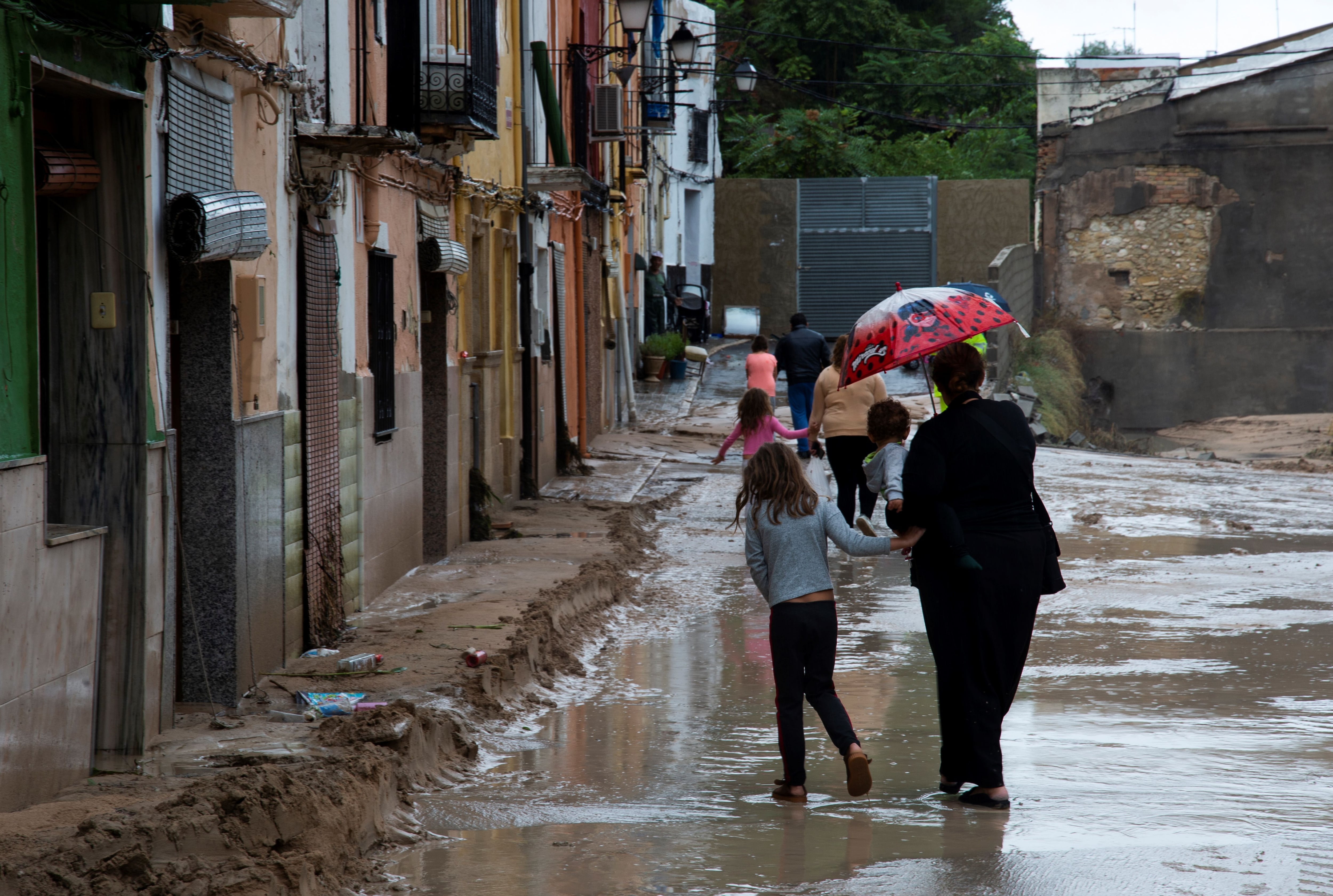 People walk on a flooded street in Ontinyent on September 12, 2019 as torrential rains hit southeastern Spain overnight, sparking major flooding in the Valencia region and closing schools in a move affecting a quarter of a million children. (Photo by JOSE JORDAN / AFP)        (Photo credit should read JOSE JORDAN/AFP via Getty Images)