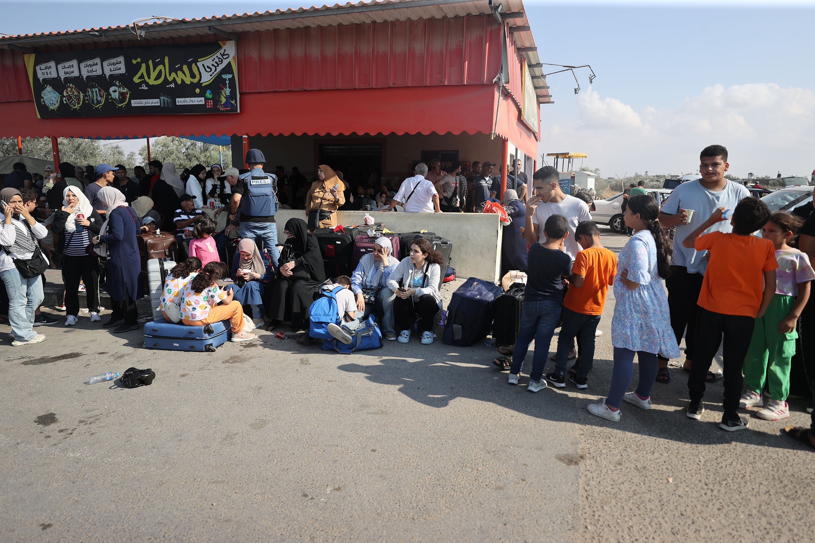 Los habitantes de Gaza con pasaportes extranjeros esperan llegar a la puerta fronteriza de Rafah y esperan para cruzar a Egipto mientras continúan los ataques de Israel contra la Franja de Gaza