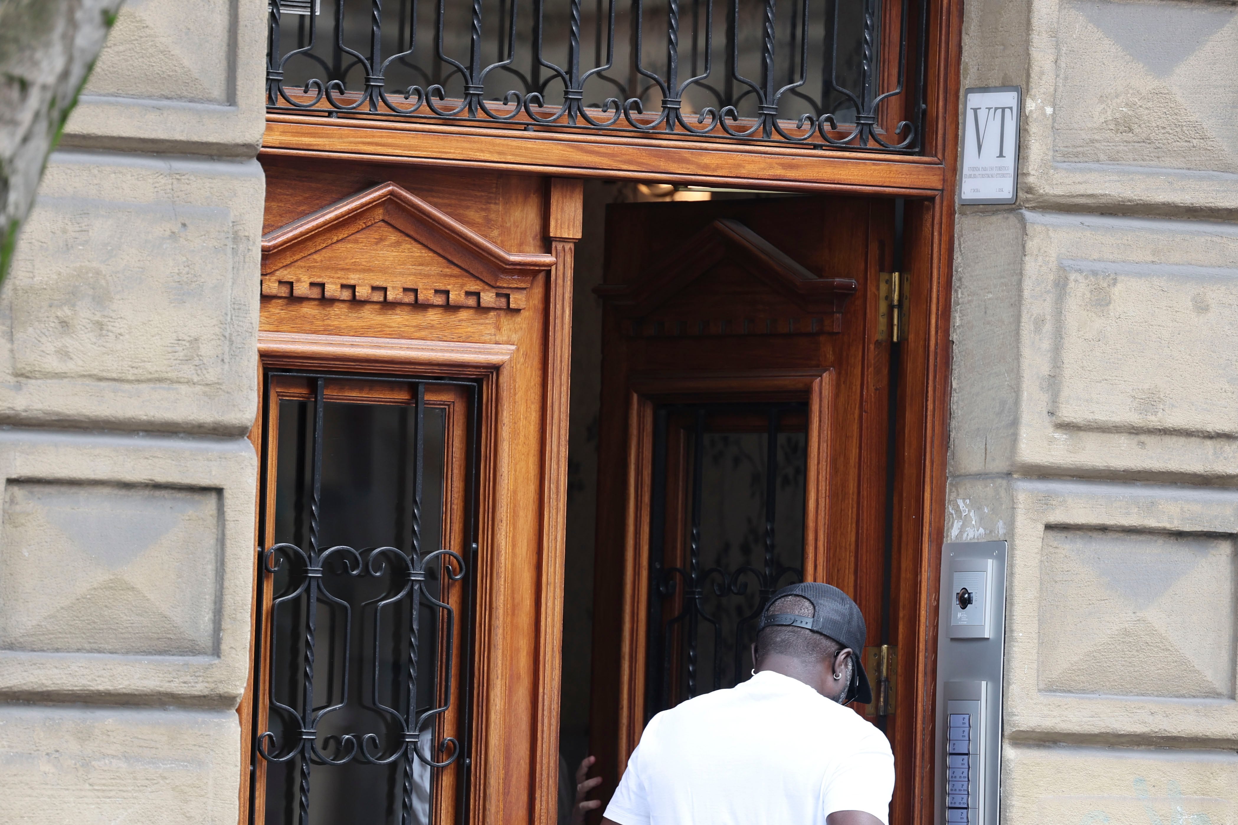 BILBAO, 30/07/2025.- Una persona entra en un edificio donde anuncia pisos turísticos VT, este miércoles en Bilbao. La plataforma de alojamientos AirBnB ha confirmado que ha retirado 703 anuncios que no tenían número de registro, tras el requerimiento que hizo en junio el Departamento de Turismo, Comercio y Consumo del Gobierno Vasco. El Ejecutivo autonómico ha recordado que las viviendas turísticas deben contar con número de registro según la normativa de turismo. Al incumplir ese requisito legal AirBnB ha retirado los anuncios y ha informado a quienes los comercializan de sus obligaciones.EFE/Luis Tejido
