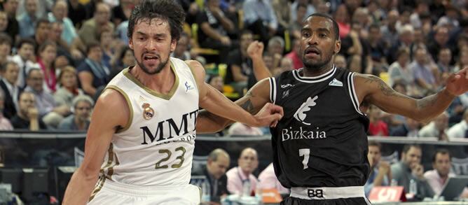 El jugador del Bizkaia Bilbao Basket, el americano Aaron Jackson (d), persigue al base del Real Madrid, Sergio Llul (i), durante el partido de liga ACB, correspondiente a la segunda jornada, jugado hoy en el Bilbao Arena de la capital vizcaína.