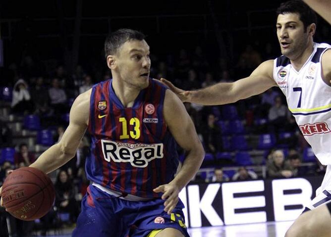 El base lituano del F.C.Barcelona, Sarunas Jasikevicius (i) intenta eludir la defensa del escolta del Fenerbahce Ulker Omer Onan, en el partido de la primera jornada del Top 16 de la Euroliga