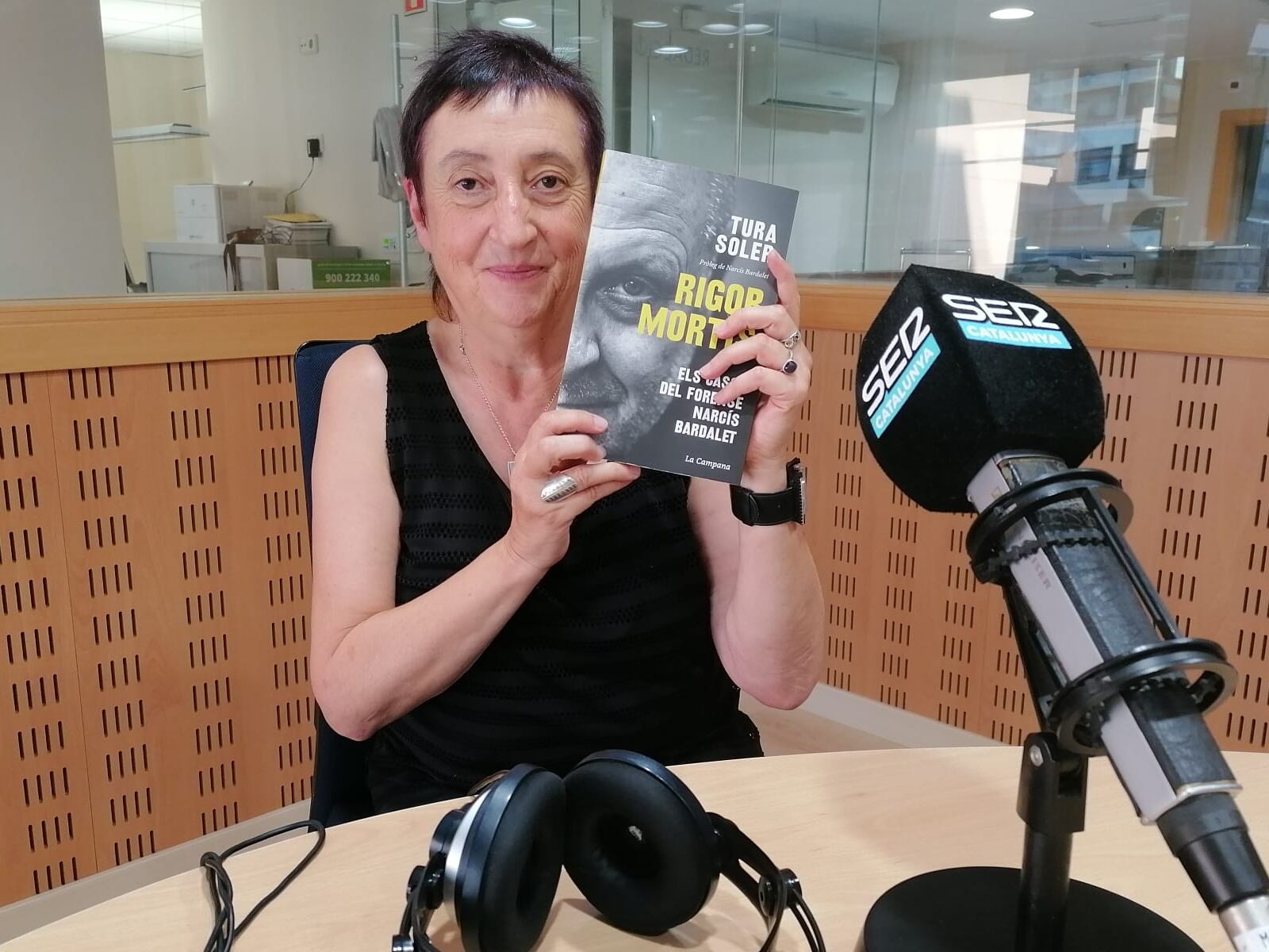 Tura Soler als estudis de Ràdio Girona amb el llibre sobre Narcís Bardalet, 'Rigor Mortis'.