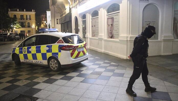 Un policía local corta una calle aledaña a la plaza donde estaba el cadáver del sacristán