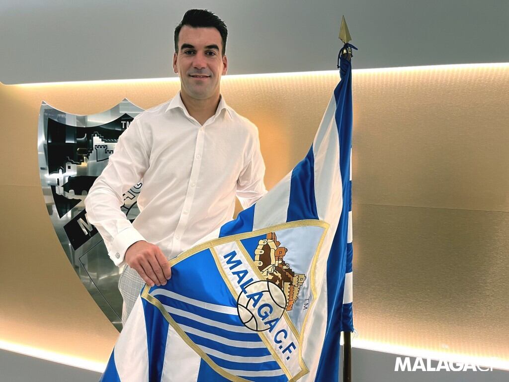 Manolo Reina posa con la bandera del Málaga CF