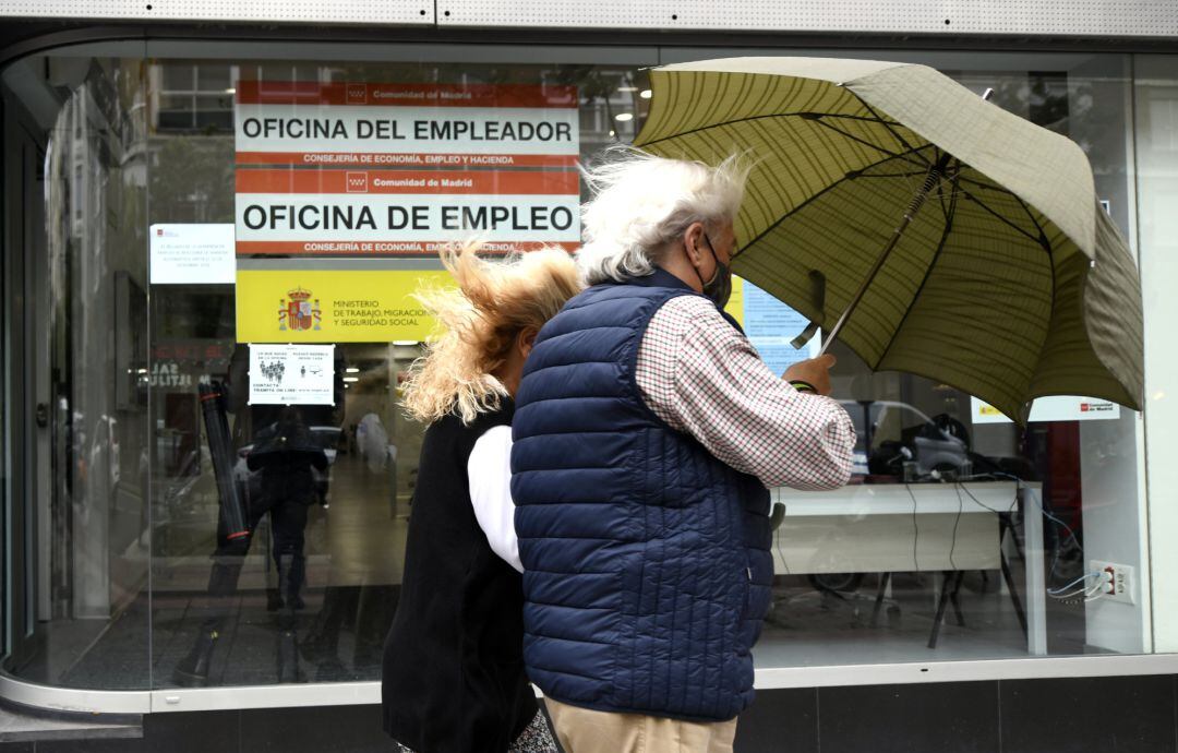 Una pareja pasa al lado de una Oficina de Empleo en Madrid 