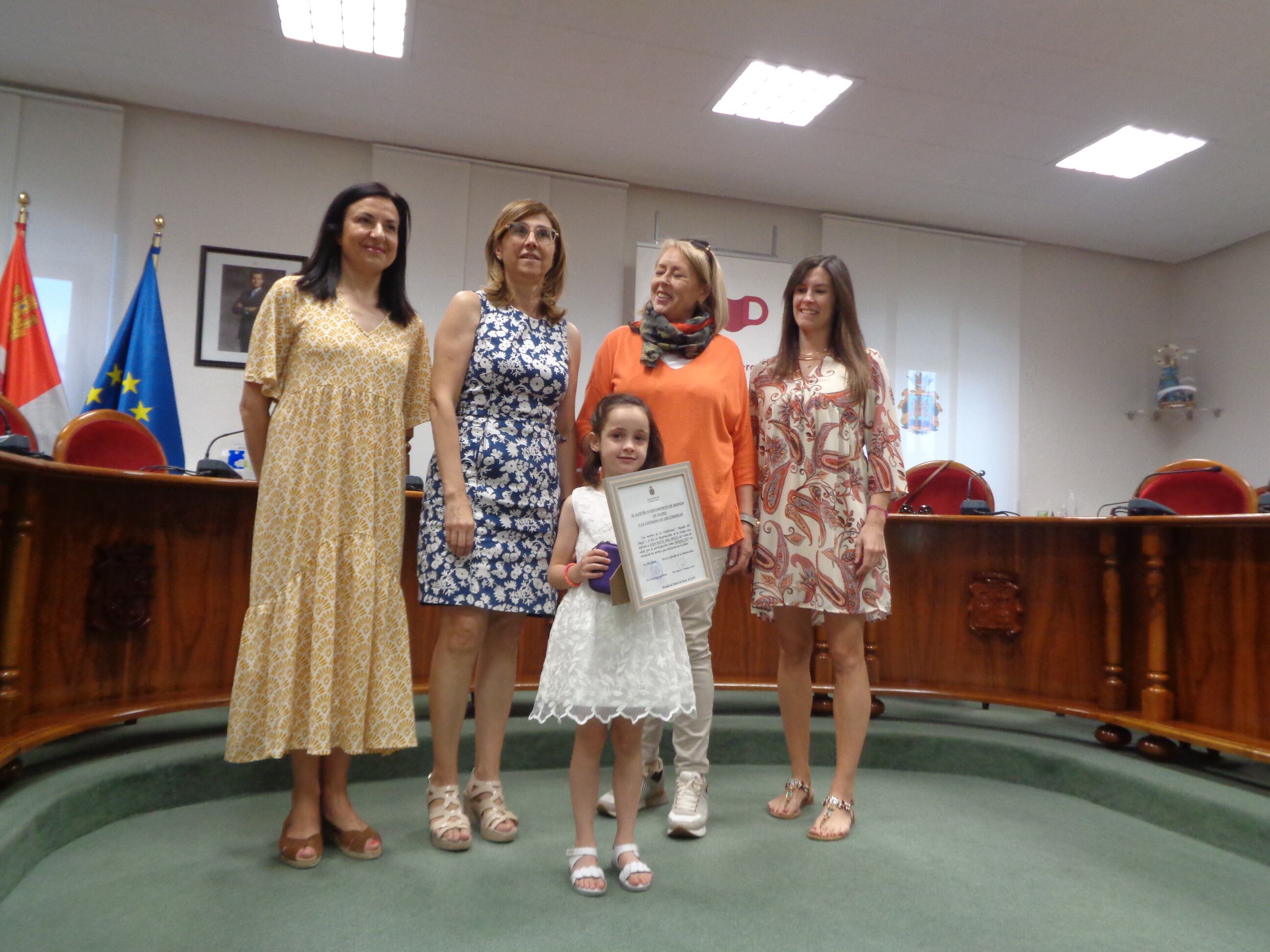 Con la sonrisa por delante, Ana posa con sus obsequios, con las tres ediles y su madre