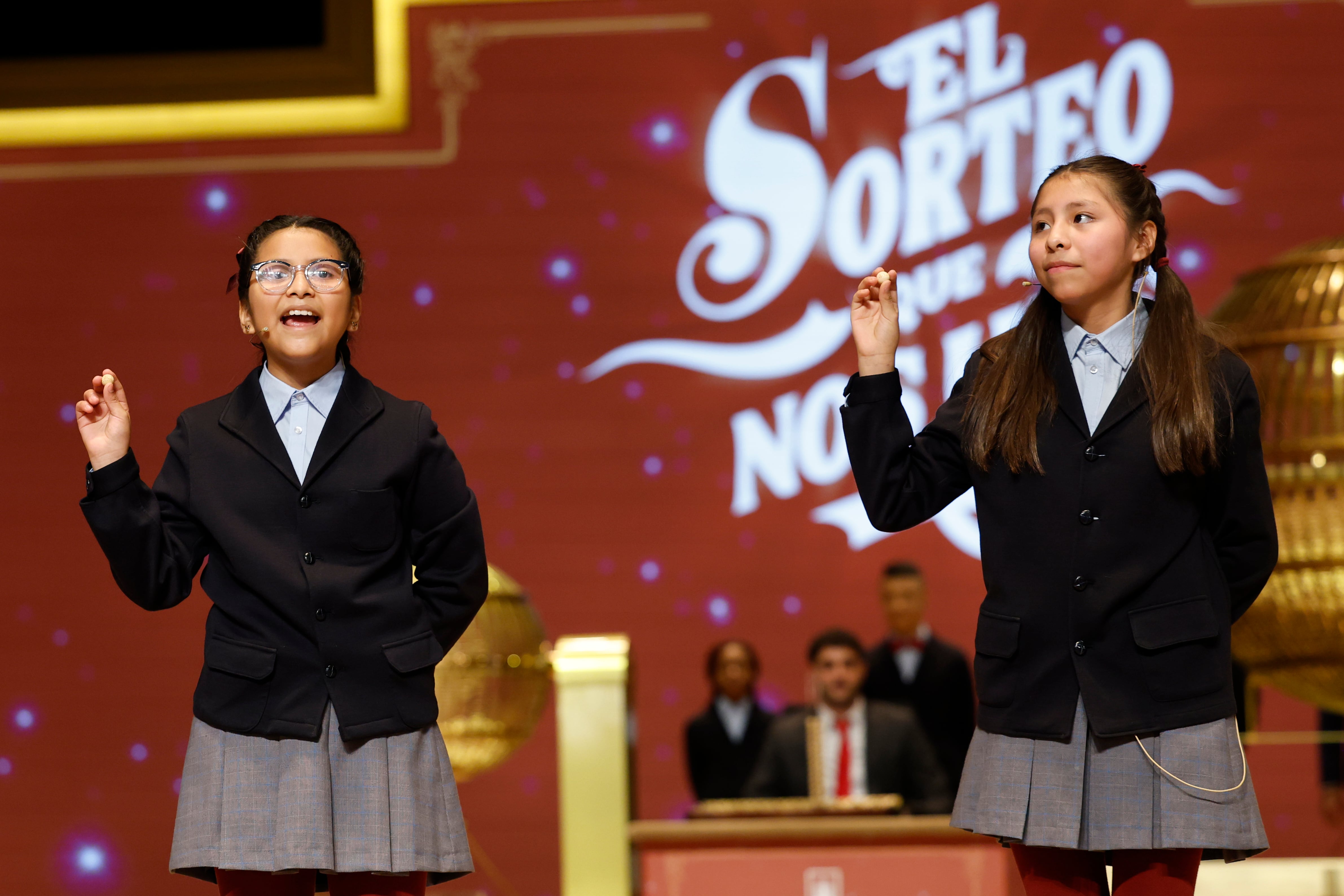 MADRID, 22/12/2025.- Alba Yadira Machaca e Italy Andrea Blanco cantan el número agraciado con el premio gordo del Sorteo de la Lotería de Navidad, dotado con 4 millones de euros a la serie, 400.000 al décimo, y que este año ha recaído en el número 79.432. EFE/Chema Moya