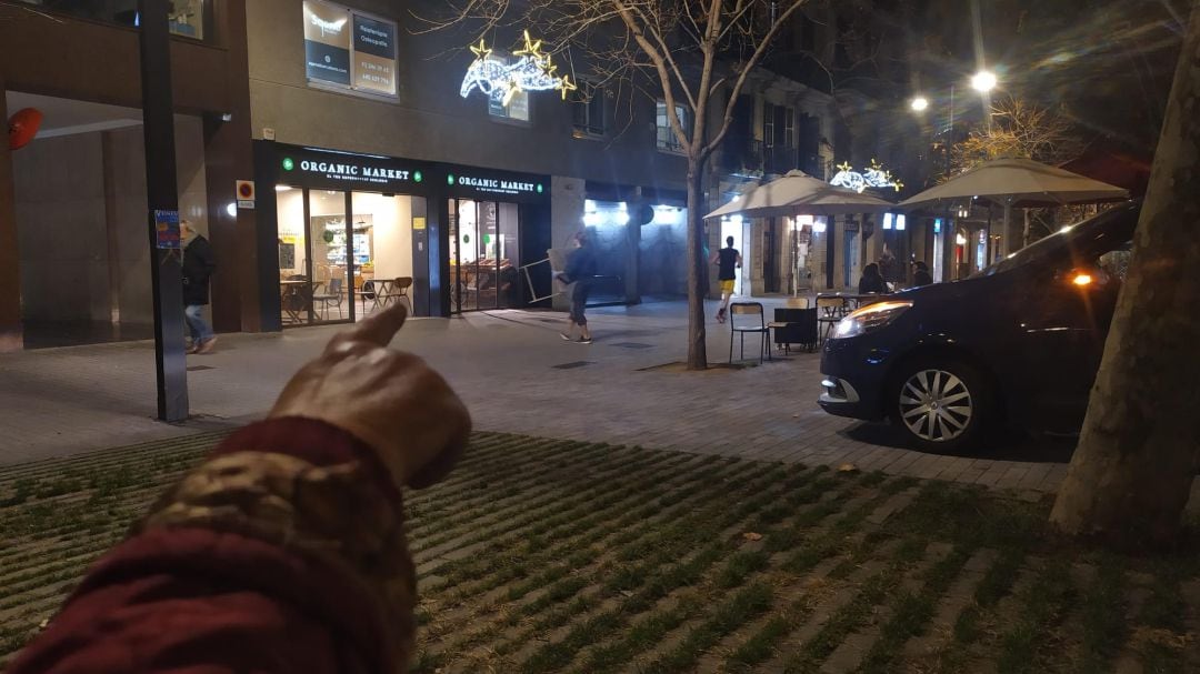 Una veïna assenyala amb el dit el punt exacte on els Mossos han fet la reconstrucció aquest matí