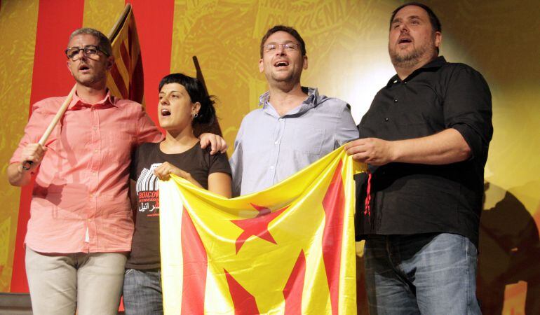 Imatge d'Anna Gabriel, Albano Dante Fachín i Oriol Junqueras amb una estelada al final de l'acte en record de la Diada del 1976 celebrada a Sant Boi de Llobregat