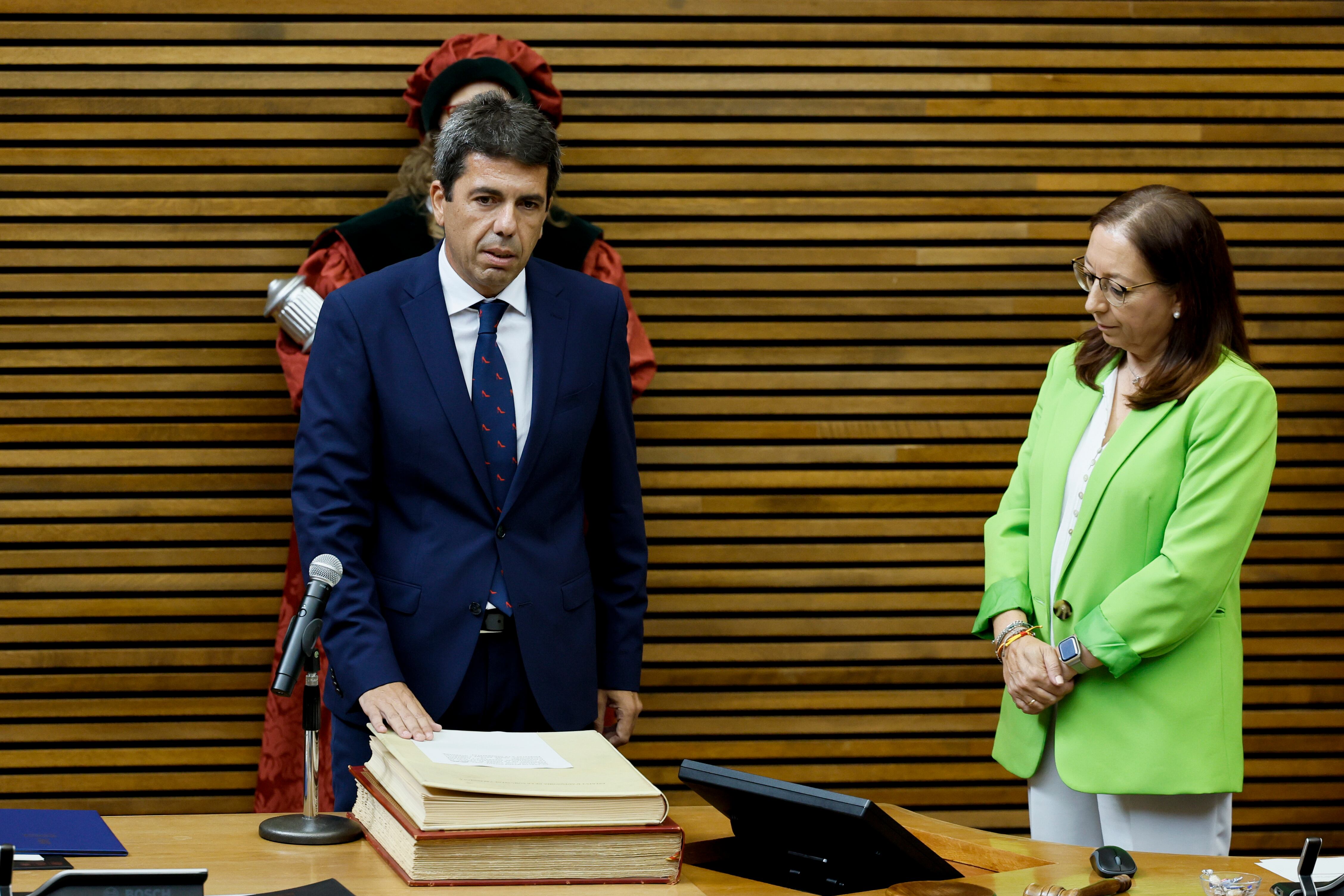 El nuevo president de la Generalitat, Carlos Mazón, del PP, jura su cargo ante la presidenta de Les Corts, Llanos Massó, de VOX, en una imagen de archivo del pleno de toma de posesión del cargo