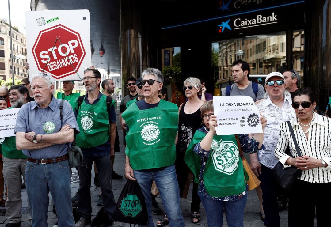 La plataforma Stop Desahucios durante una concentración convocada este martes frente a una entidad bancaria para buscar solución a dos casos de familias que van a ser desahuciadas