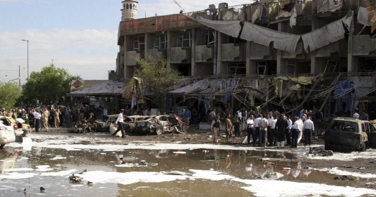 EBAG04 BAGDAD (IRAQ), 21/10/2014.- Agentes de policía y bomberos iraquíes inspeccionan la zona donde ha explosionado un coche bomba en Bagdad, Irak, hoy, martes 21 de octubre de 2014. Al menos ocho personas murieron y otras 40 resultaron heridas hoy por e