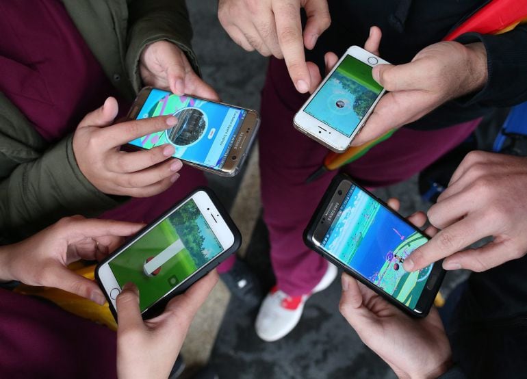 Un grupo de gente juega al Pokemon Go en sus teléfonos móviles  en Sydney, Australia. 