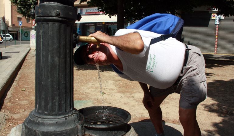 Un hombre bebiendo para sobrellevar las altas temperaturas