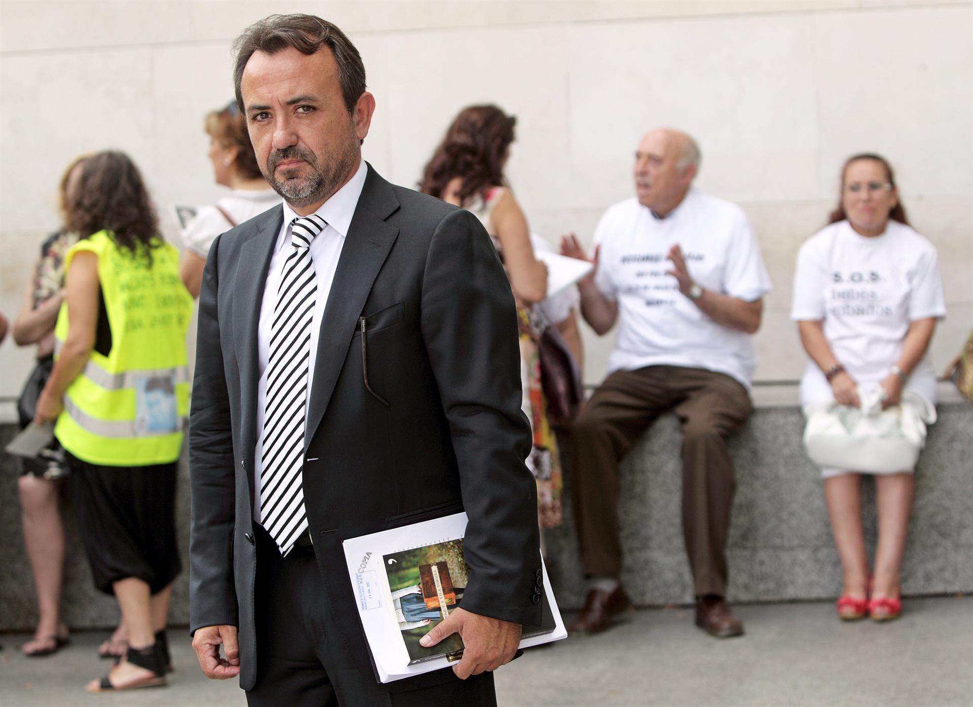 El abogado Enrique Vila, uno de los veintiún valencianos afectados por los casos de los bebés robados posa ante la puerta principal de la Ciudad de la Justica de Valencia donde presentaron una demanda conjunta contra la Casa Cuna Santa Isabel de Valencia (junio, 2012)