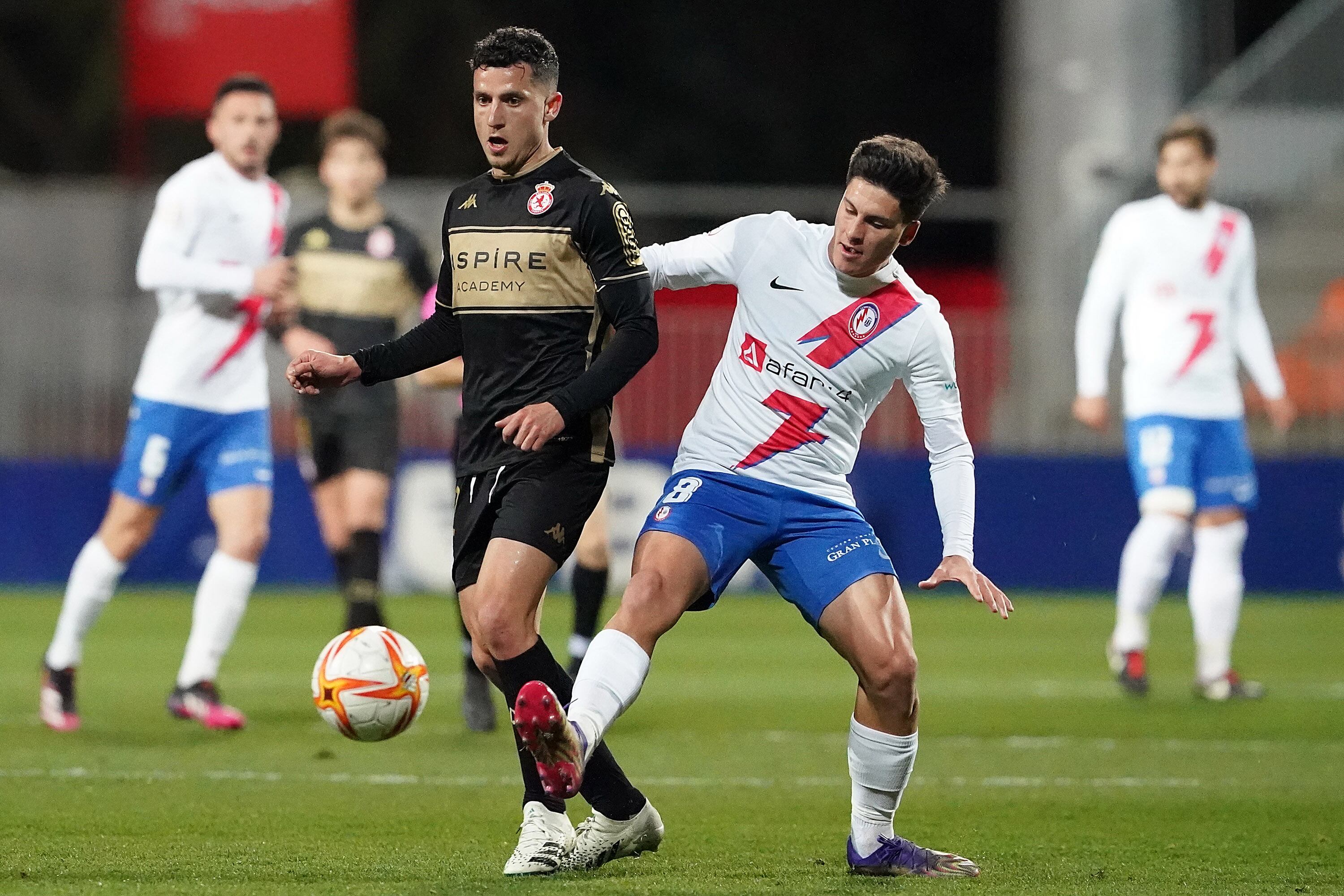 Sierra golpea el balón ante el centrocampista rayista Juanjo