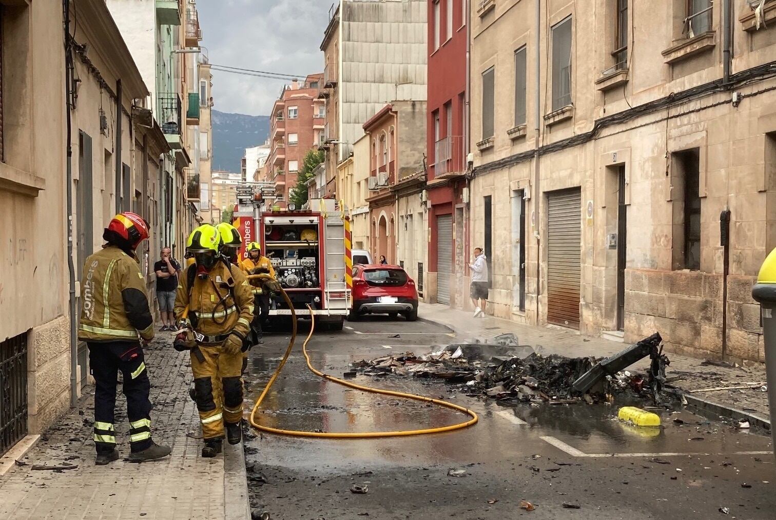 Una dotación de bomberos del parque de la Muntanya ha extinguido las llamas que han arrasado los tres contenedores en la calle Pinto Casanova de Alcoy.