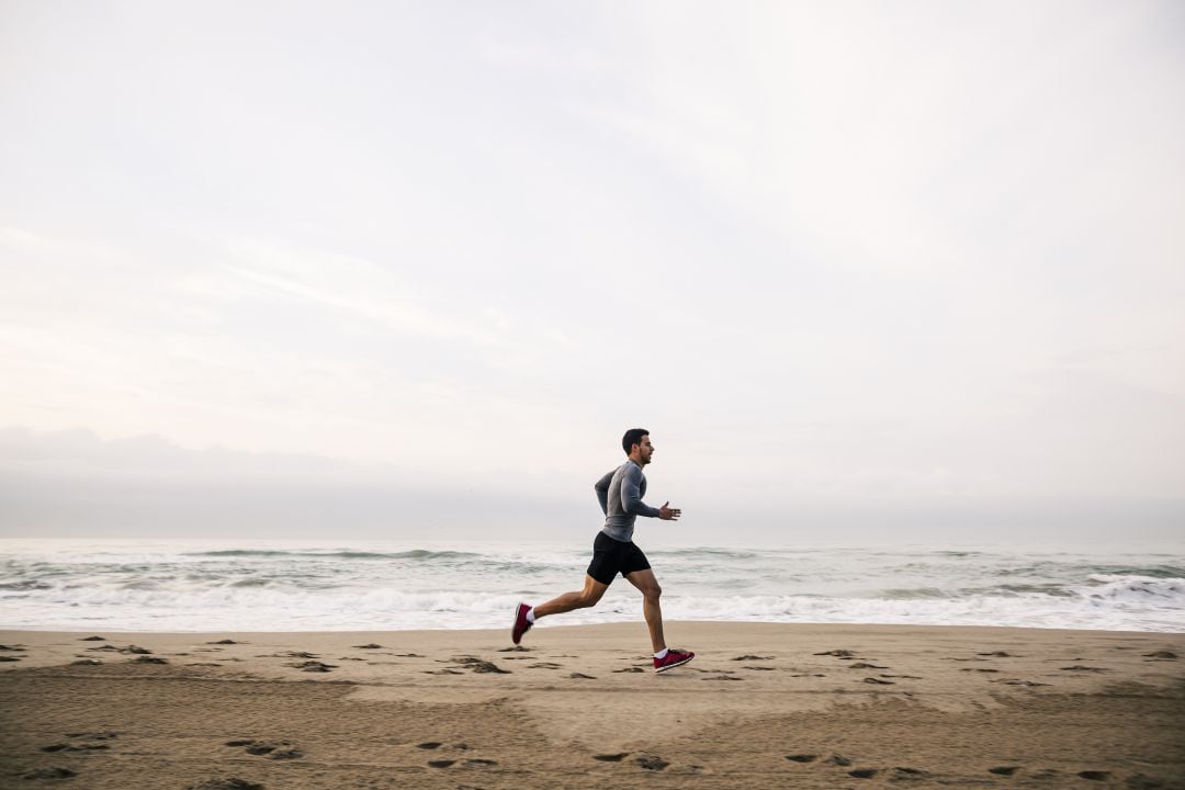 Hombre corriendo en la playa.